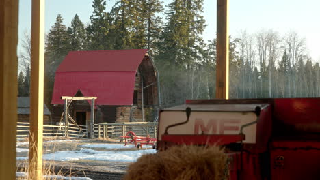 View-of-quaint-red-barn-through-farm-machinery