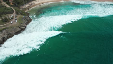 Birdseye-drone-shot-of-surfers-at-Tofinho-Point,-Mozambique