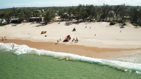Toma-Aérea-De-Drones-De-Un-Bote-De-Buceo-En-Las-Costas-Arenosas-De-Tofo,-Mozambique