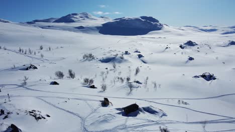 Snowy-Landscape-With-The-View-Of-STF-Unna-Allakas-Mountain-Cabin-In-Kiruna,-Sweden---aerial-drone-shot