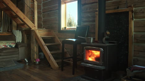 Interior-log-cabin-with-fireplace-stove-burning-brightly