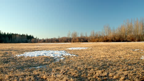 Pan-across-semi-frozen-open-farm-field