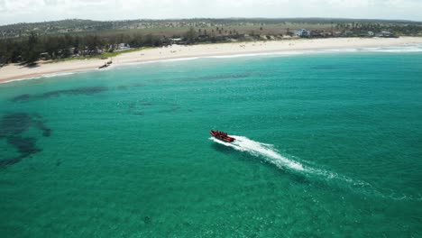 Drone-shot-following-a-scuba-diving-boat-beaching-itself-on-the-shore-in-Tofo,-Mozambique