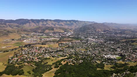 Drone-Cresting-Hill-Para-Revelar-La-Hermosa-Ciudad-De-San-Luis-Obispo-Y-El-Paisaje-Circundante