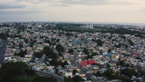 AERIAL---Dusk-over-the-urban-sprawl-of-Santo-Domingo,-Dominican-Republic,-forward
