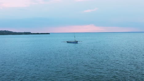 Slow-panning-drone-shot-of-a-lonesome-fishing-boat-in-Tofo,-Mozambique