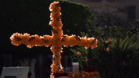 Nahaufnahme-Eines-Ornaments-Eines-Katholischen-Kreuzes,-Das-Mit-Gelben-Cempasuchil-blumen-Und-Monarchschmetterlingen-Während-Der-Feier-Des-Totentages-In-Mexiko-Geschmückt-Ist