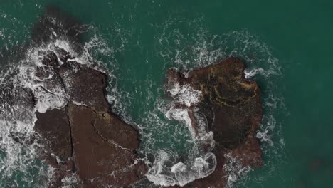 Aerial-view-above-a-shipwreck,-in-shallow,-rocky-water,-on-the-coast-of-Tel-aviv,-Israel---rising,-drone-shot