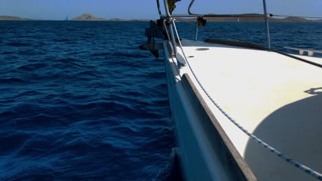 view-of-a-very-blue-and-wavy-sea-and-hills-on-the-horizon-from-a-white-yacht-sailing-calmly-on-a-sunny-summer-day-in-a-south-european-country