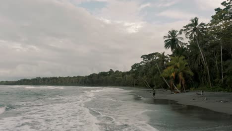 Tourist-Walking-Alone-At-The-Beach-In-Punta-Mona,-Southern-Caribbean-Coast-Of-Costa-Rica