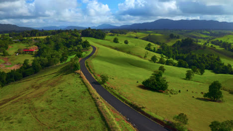 Countryside-Landscape-With-Scenic-Road-And-Rolling-Hills-In-Atherton-Tablelands,-Queensland,-Australia---aerial-drone-shot