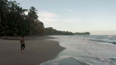 Sandy-Beach-In-Punta-Mona,-Costa-Rica-With-Man-Walking-Alone