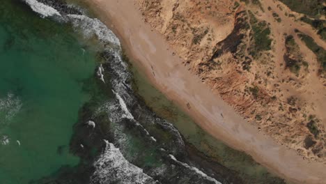 Top-down-view-ascend-Scenery-Coastline-transparent-emerald-sea-on-sandy-beach,-Netanya