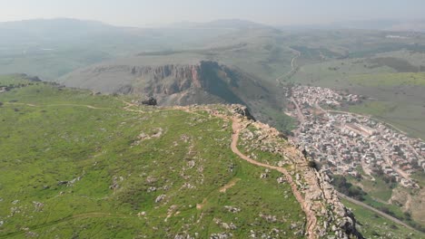 Aerial-view-above-the-Mount-Arbel-peak,-overlooking-the-Hamaam-village,-in-Israel---rising,-drone-shot