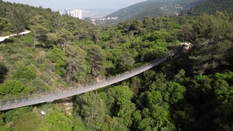 Aerial-view-around-the-hanging-bridge,-in-sunny-Haifa-Nesher-Park,-Israel---circling,-drone-shot