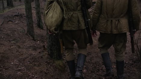Dos-Soldados-De-La-Segunda-Guerra-Mundial-Caminando-En-Un-Bosque-Con-Rifles-Y-Cascos-Y-Botas-Fumando-Cigarrillos