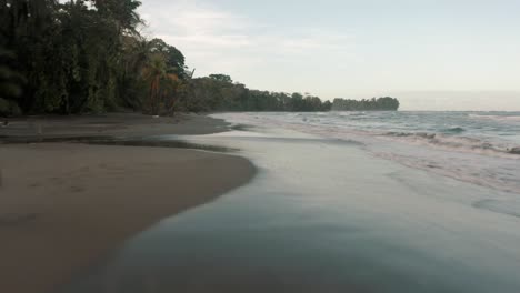 Playa-En-La-Costa-Sur-Del-Caribe-En-Punta-Mona,-Costa-Rica-Con-Un-Hombre-Caminando-Sobre-La-Arena
