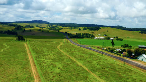 Grüne-Felder-Und-Landstraße-In-Atherton-Tablelands,-Queensland,-Australien---Luftdrohnenaufnahme