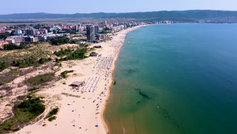 4K-moving-forward-drone-clip-over-an-exotic-golden-sand-beach-in-Sunny-Beach,-Bulgaria