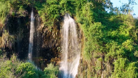 The-natural-waterfall-that-flows-down-the-mountain-is-lit-by-the-evening-sun
