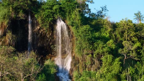 Ein-Weiter-Blick-Auf-Den-Natürlichen-Wasserfall,-Der-Den-Berg-Hinunterfließt,-Wird-Von-Der-Abendsonne-In-Thailand-Beleuchtet