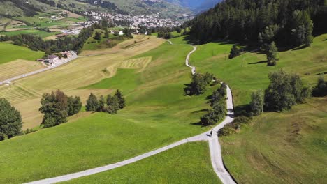 Aerial:-swiss-valley-and-mountain-biker-following-a-path