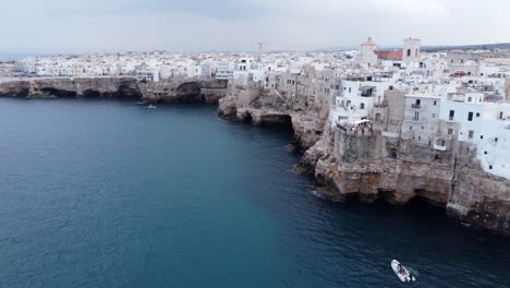 Drone-View,-Flight-Passing-By-Houses-on-Sea-Cliffs,-Polignano-a-Mare