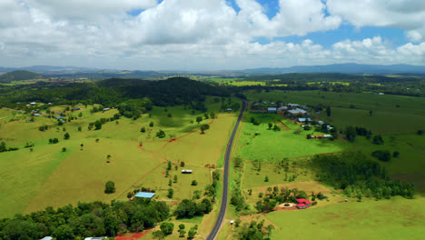 Green-Landscape-With-A-Country-Road-In-The-Field-In-Atherton-Tablelands,-Queensland,-Australia---aerial-drone-shot