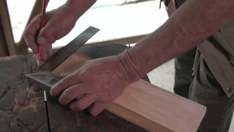 Taking-measurements-of-wood-piece-with-line-and-pencil