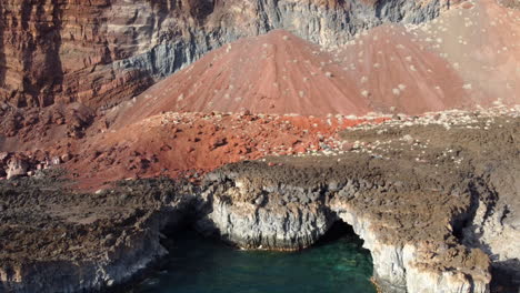 Cala-Tacoron-Bay-with-sea-washed-ocher-cliffs-created-by-volcanic-activity,-El-Hierro---aerial-shot
