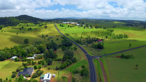 Vehículo-Que-Viaja-Por-Una-Pintoresca-Carretera-Rural-En-Atherton-Tablelands,-Queensland,-Australia---Toma-Aérea-De-Drones