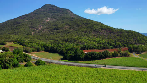 Green-Fields-And-Forest-Mountains-With-Traveling-Cars-At-Country-Road-In-Cairns,-QLD-Australia
