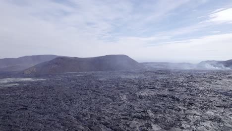 Flying-Over-Steaming-Lava-Fields-With-Sulfur-Smoke-Rising-From-The-Ground---aerial-drone-shot