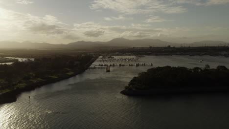Ascending-aerial-shot-of-marina-harbor-with-docking-yachts-and-boats-in-Gladstone,Australia-during-sunset