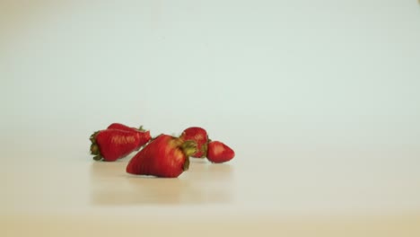 Leckere-Große-Reife-Erdbeeren-Fallen-Auf-Den-Tisch-Und-Rollen-Vom-Bildschirm,-Köstliche-Gesunde-Vitamine-Bio-Früchte,-Stationäre-Nahaufnahme