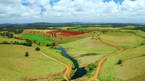 Aerial-View-Of-Lush-Green-Fields-And-River-In-Atherton-Tablelands,-Queensland,-Australia---drone-shot