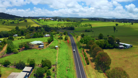 Aerial-View-Of-Scenic-Country-Road-With-Vehicle-Traveling-In-Atherton-Tablelands-Region,-Queensland,-Australia---drone-shot