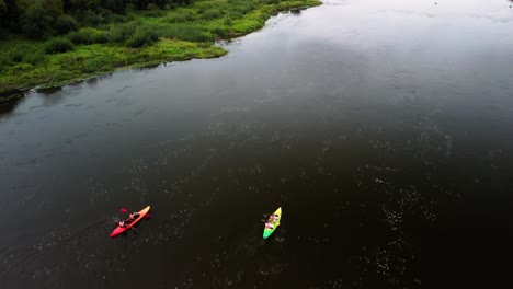drone-shot-of-two-kayaks-in-the-river,-people-are-kayaking