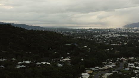 Toma-Aérea-Ascendente-De-Las-Montañas-Y-La-Ciudad-De-Cairns-Durante-Un-Día-Nublado-En-Queensland,-Australia