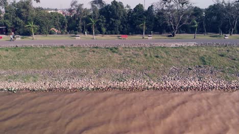 View-of-the-muddy-water-waves-of-the-Sukhna-lake-on-a-windy-day-near-the-pedestrian-lane-in-Chandigarh
