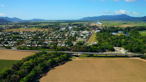 Road-With-Vehicles-Traveling-On-Suburban-Area-Of-Cairns,-Queensland,-Australia---aerial-drone-shot