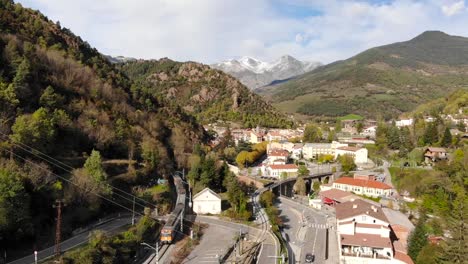 Antena:-Tren-Regional-Entrando-En-Una-Estación-En-Los-Pirineos-Con-Picos-Nevados-Al-Fondo
