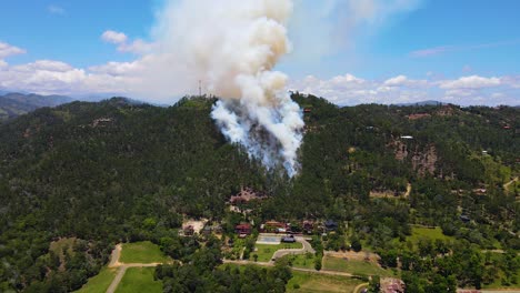 Air-pollution-caused-by-a-forest-fire-in-the-mountains,-wildlife-and-nature-destruction-due-to-human-inconsistency,-aerial-view