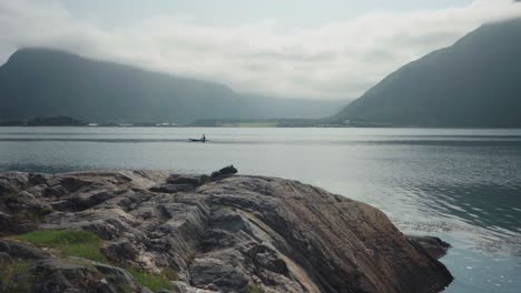 Hombre-Remando-En-El-Lago-Pacífico-Durante-La-Mañana-Nublada-Cerca-De-Mardalsfossen-En-Molde,-Noruega