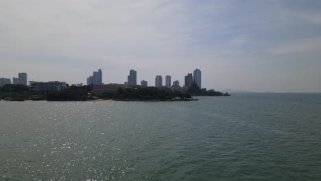 Aerial-footage-over-the-sea-towards-the-Sanctuary-of-Truth-and-towards-city-of-Pattaya-in-Chonburi,-Thailand