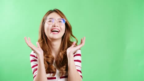 Cheerful-Asian-woman-gesturing-with-hands-covering-her-face-and-opening-with-happy-smiling-face-green-screen-background
