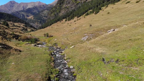Aerial:-valley-with-a-small-stream-among-high-peaks-in-the-Pyrenees