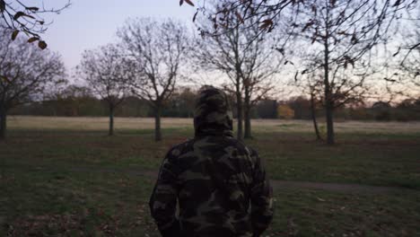 Following-a-man-walking-his-dog-on-a-chilly-evening-in-a-camouflage-jacket