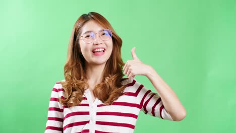 Fröhliche-Junge-Asiatin-Mit-Brille,-Die-Die-Hände-Hochhebt,-Zittert-Und-Faustpumpe-Vor-Glück-Hat,-Lächelndes-Frauengesicht,-Grüner-Bildschirmhintergrund