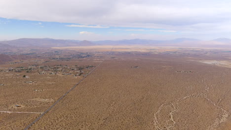 High-altitude-aerial-view-of-towns-in-the-the-Mojave-Desert-basin-surrounded-by-mountains